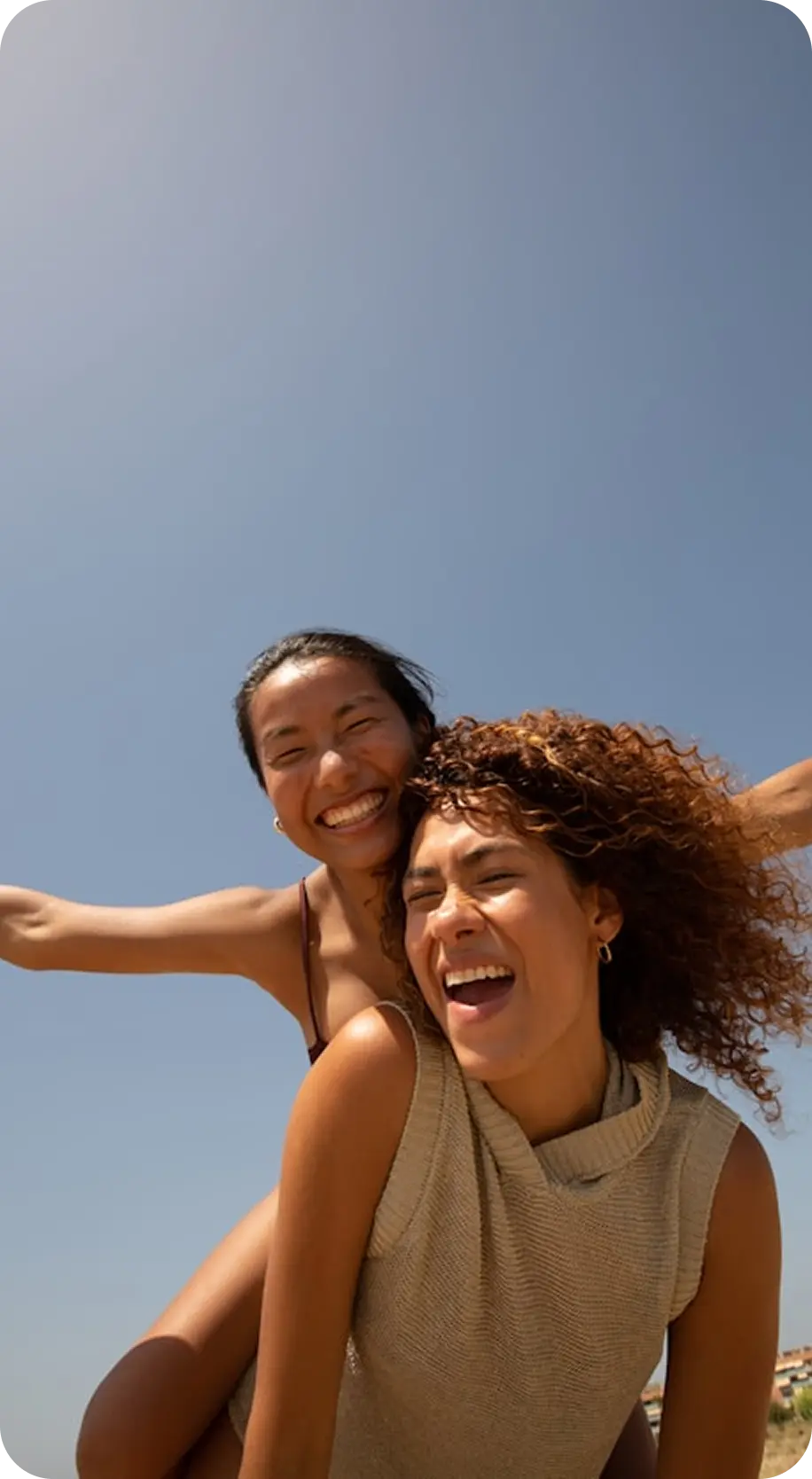 Two friends laughing together outdoors